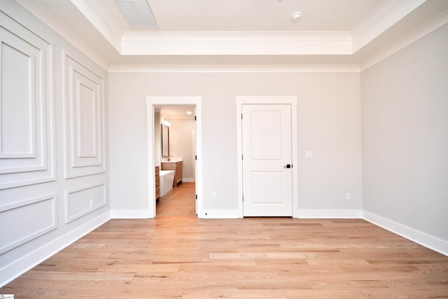unfurnished bedroom featuring baseboards, light wood-type flooring, crown molding, and visible vents