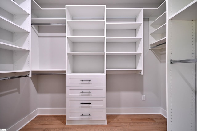 walk in closet with light wood-style flooring