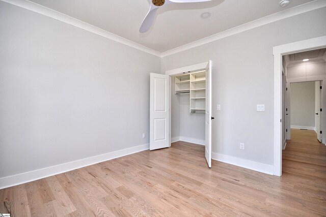unfurnished bedroom featuring baseboards, ornamental molding, attic access, ceiling fan, and light wood finished floors