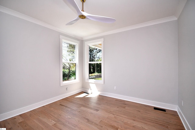 empty room featuring crown molding, ceiling fan, wood finished floors, and baseboards