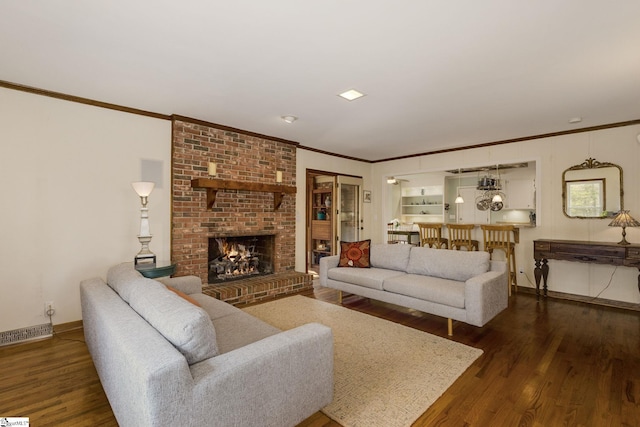 living room featuring crown molding, wood finished floors, baseboards, and visible vents