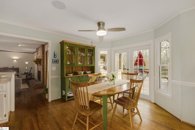 dining space featuring a wealth of natural light, a ceiling fan, crown molding, and wood finished floors