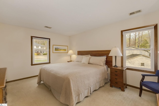 bedroom featuring visible vents, light colored carpet, and baseboards