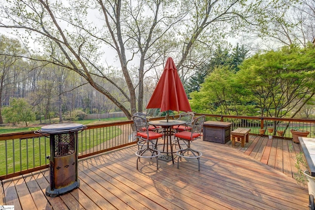 wooden terrace featuring a yard and outdoor dining area
