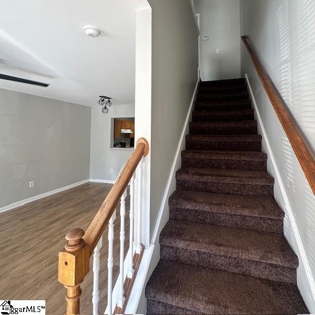 stairway with baseboards and wood finished floors