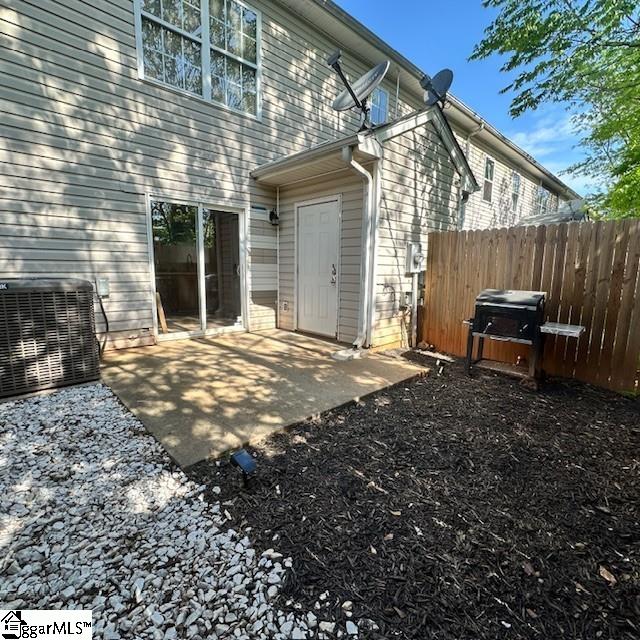 exterior space with a patio area, central air condition unit, and fence