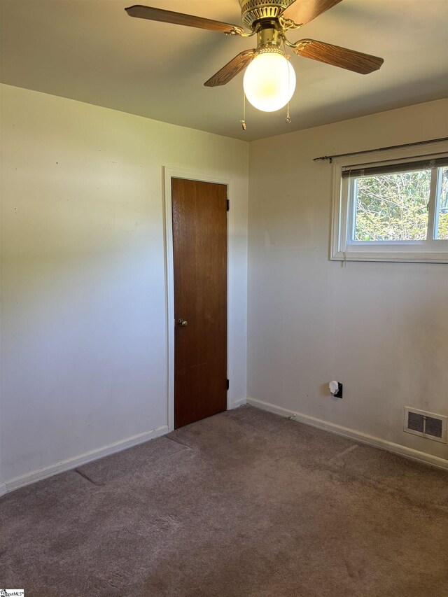 unfurnished room with visible vents, baseboards, carpet flooring, and ceiling fan