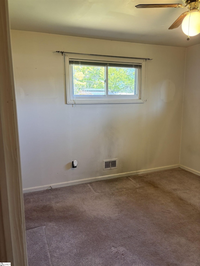 carpeted spare room with plenty of natural light, visible vents, baseboards, and ceiling fan
