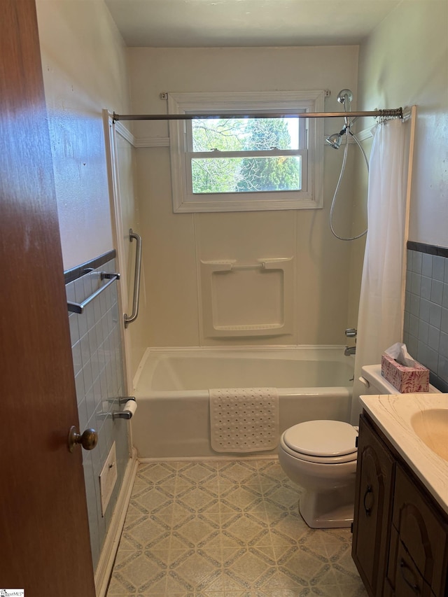 full bath featuring tile walls, toilet, shower / bath combo with shower curtain, and vanity