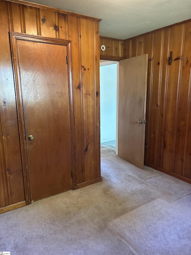 corridor featuring carpet and wooden walls