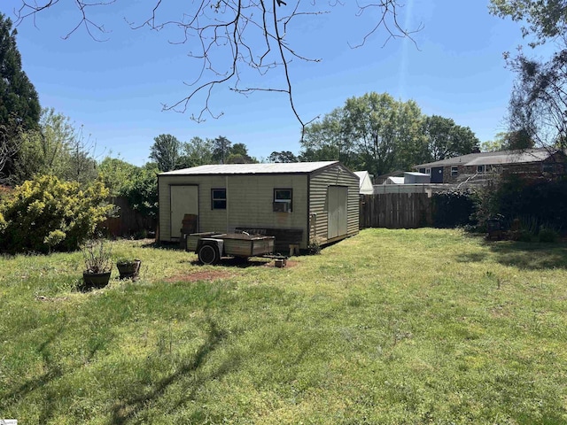 back of house with a yard, fence, an outdoor structure, and a shed