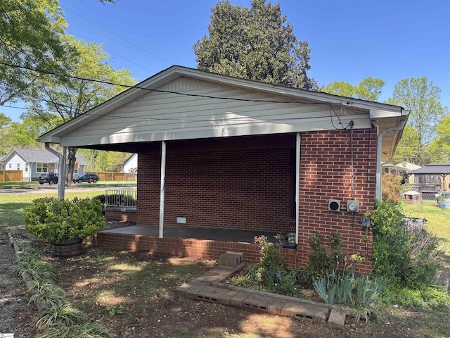 view of property exterior featuring a porch and brick siding