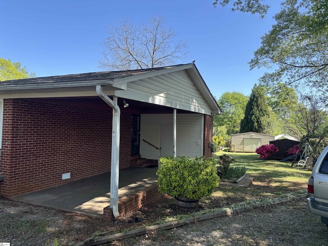 view of property exterior featuring entry steps, an outdoor structure, and brick siding