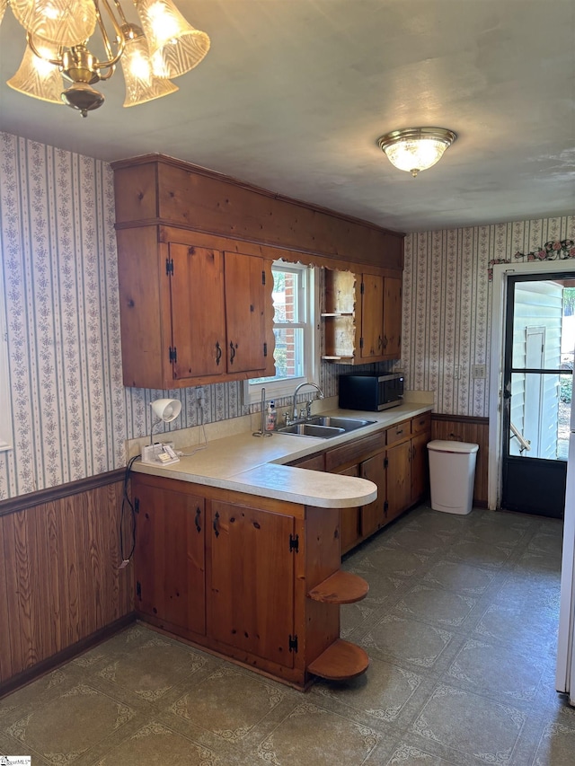 kitchen featuring wallpapered walls, a sink, open shelves, and stainless steel microwave