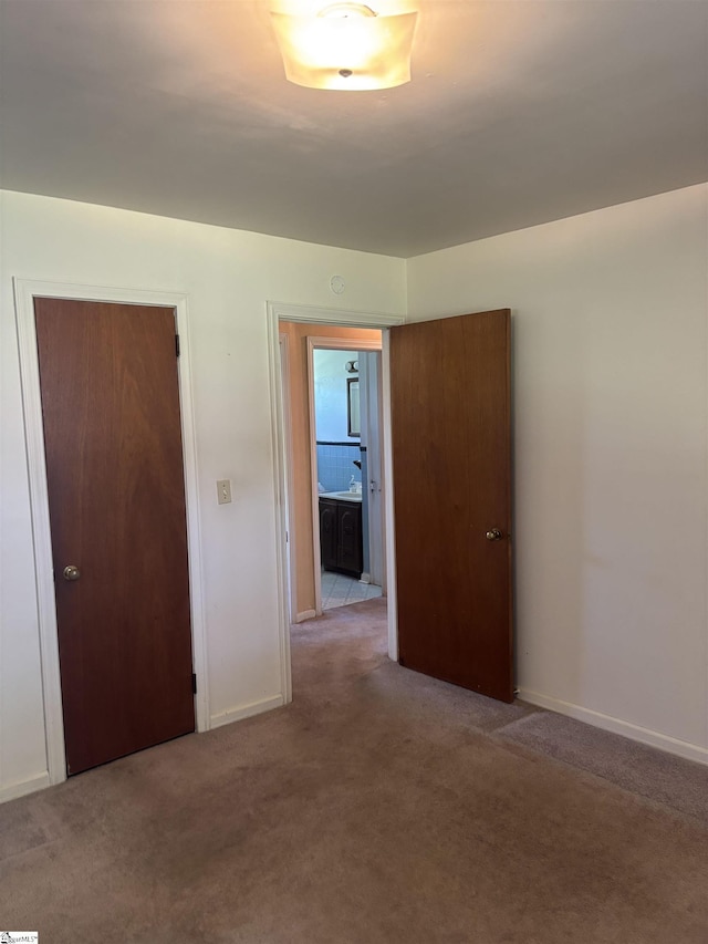 spare room featuring baseboards and carpet