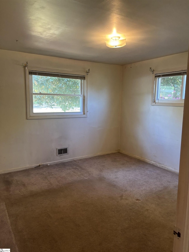 spare room with baseboards, visible vents, and carpet floors