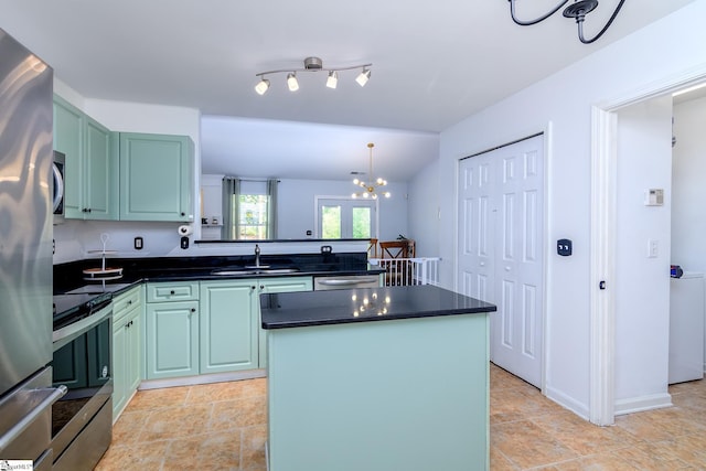 kitchen featuring a sink, dark countertops, a peninsula, stainless steel appliances, and a kitchen island