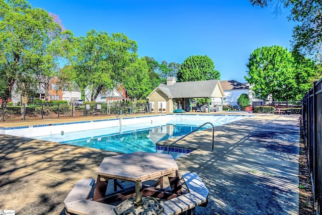community pool with a patio and fence