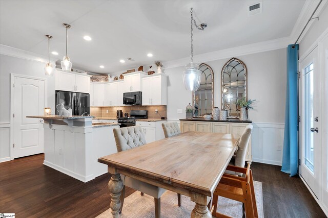 dining room with visible vents, ornamental molding, dark wood-style floors, recessed lighting, and wainscoting