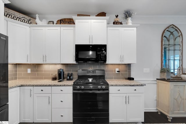 kitchen featuring backsplash, light stone counters, white cabinetry, and black appliances