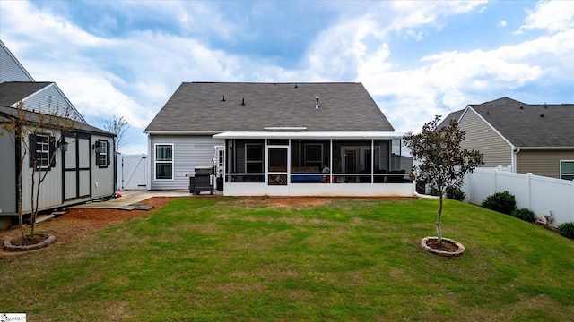 rear view of property with a yard, a fenced backyard, and a sunroom