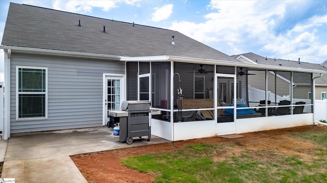 rear view of house featuring a sunroom, roof with shingles, a patio area, and ceiling fan