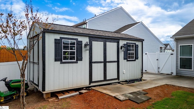 view of shed with fence and a gate