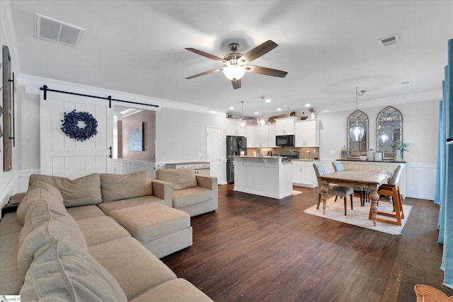 living area with dark wood-type flooring, visible vents, crown molding, and a ceiling fan