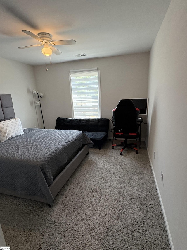 carpeted bedroom with visible vents, a ceiling fan, and baseboards