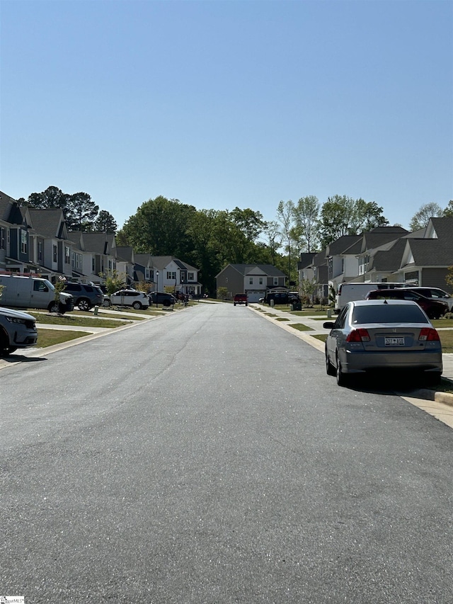 view of road with a residential view, curbs, and sidewalks