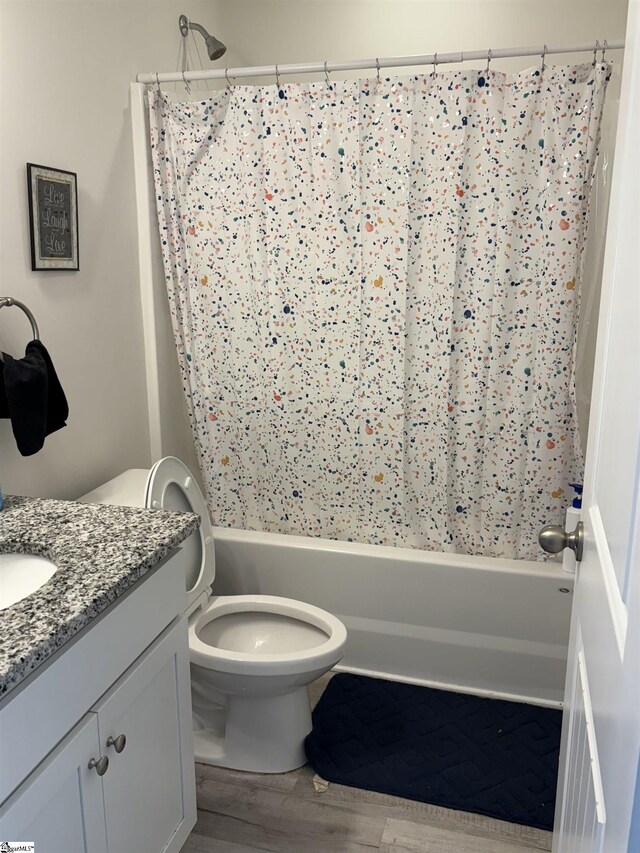 full bath with wood finished floors, vanity, toilet, and shower / bath combo