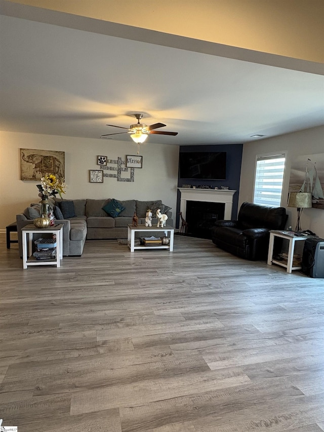 living room with wood finished floors, a fireplace, and ceiling fan