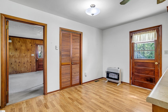 interior space featuring baseboards, heating unit, and light wood-style floors