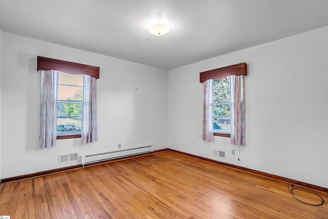 spare room featuring visible vents, a baseboard radiator, and a wealth of natural light