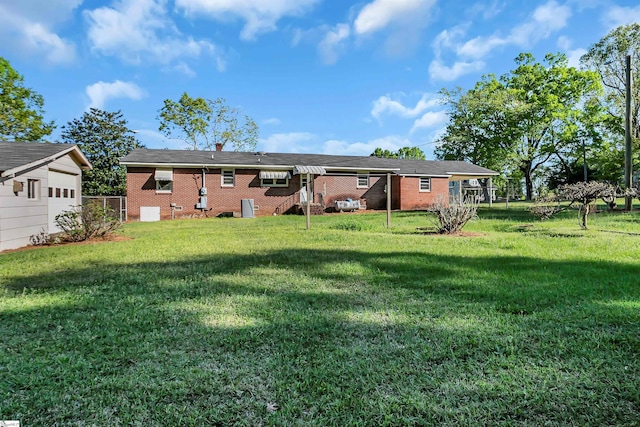 rear view of house featuring a yard and brick siding
