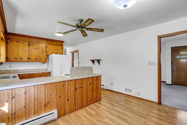 kitchen with visible vents, a baseboard radiator, freestanding refrigerator, ceiling fan, and light countertops