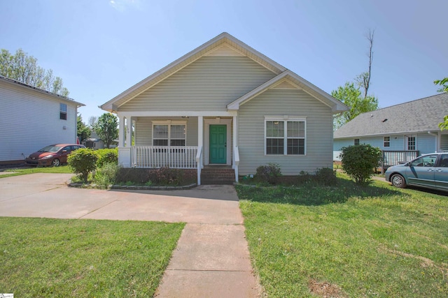 bungalow with covered porch and a front lawn
