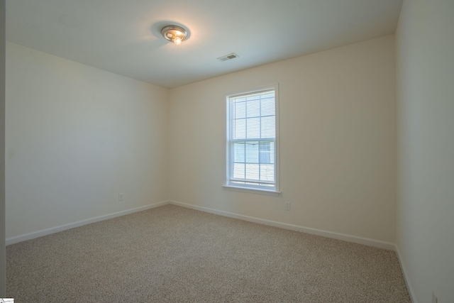 carpeted spare room with baseboards and visible vents