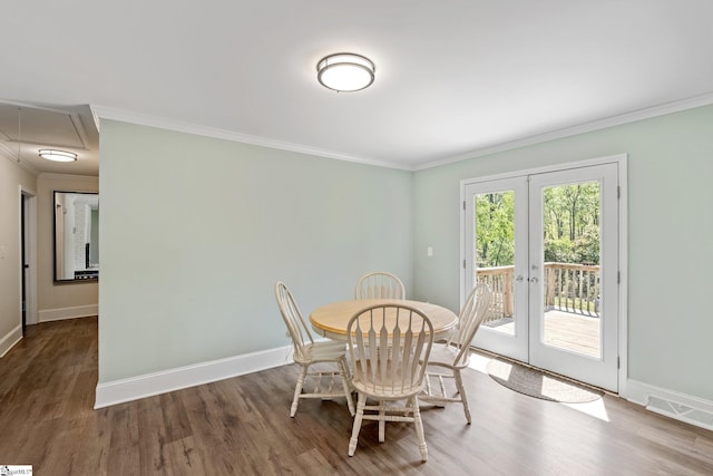 dining room featuring crown molding, visible vents, wood finished floors, french doors, and baseboards
