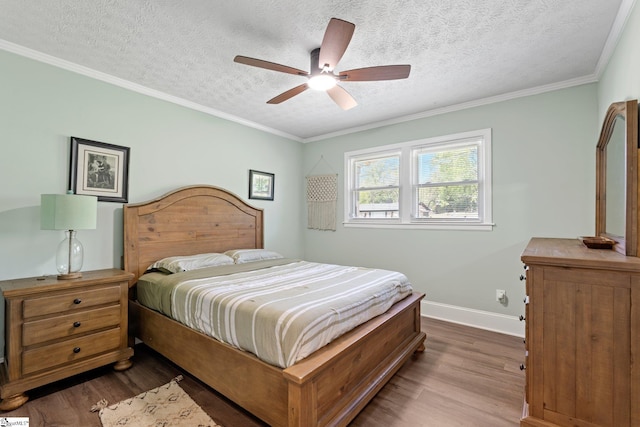 bedroom featuring a textured ceiling, baseboards, and wood finished floors