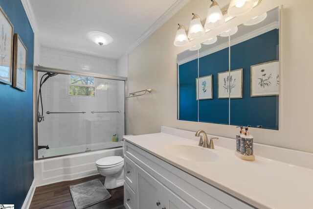 bathroom with bath / shower combo with glass door, toilet, crown molding, vanity, and wood finished floors