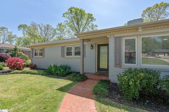 view of front facade with a front yard and brick siding