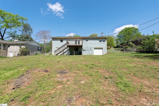 back of property featuring an attached garage, stairs, a deck, fence, and a lawn