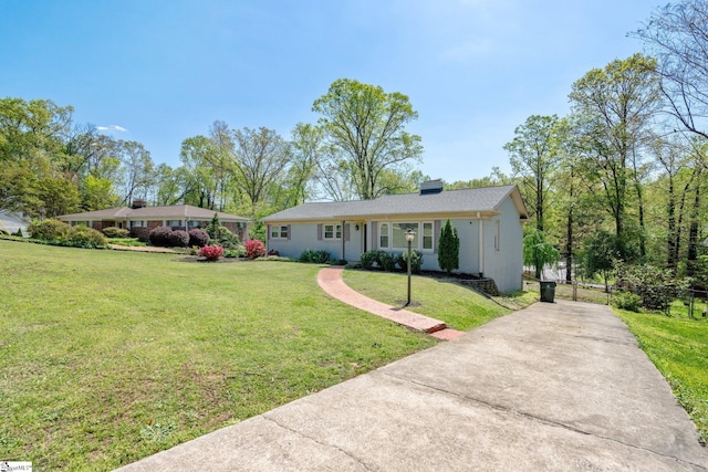 ranch-style house featuring driveway and a front yard