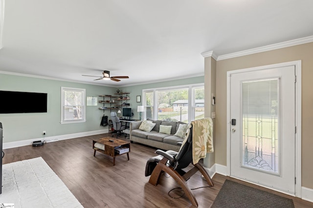 living area with crown molding, baseboards, and a ceiling fan