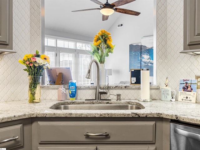 kitchen featuring visible vents, a sink, a ceiling fan, gray cabinetry, and decorative backsplash