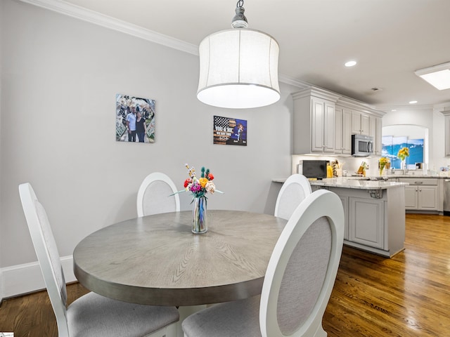 dining space with crown molding, recessed lighting, and wood finished floors