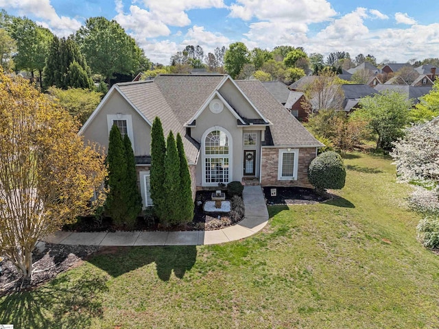 view of front facade featuring a shingled roof, stucco siding, stone siding, and a front lawn