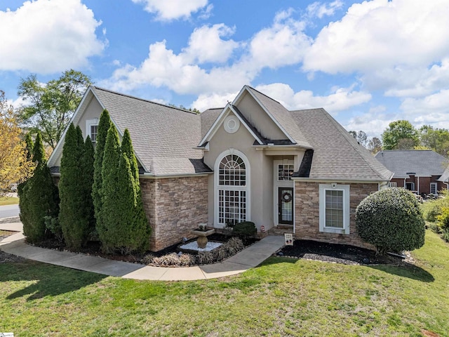 ranch-style house featuring roof with shingles, stucco siding, stone siding, and a front lawn