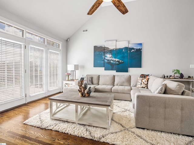 living room with high vaulted ceiling, visible vents, a ceiling fan, and wood finished floors